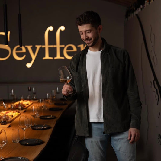 Winzer bei einer Weinverkostung mit Weinglas im Weingut Seyffer in Weinsberg